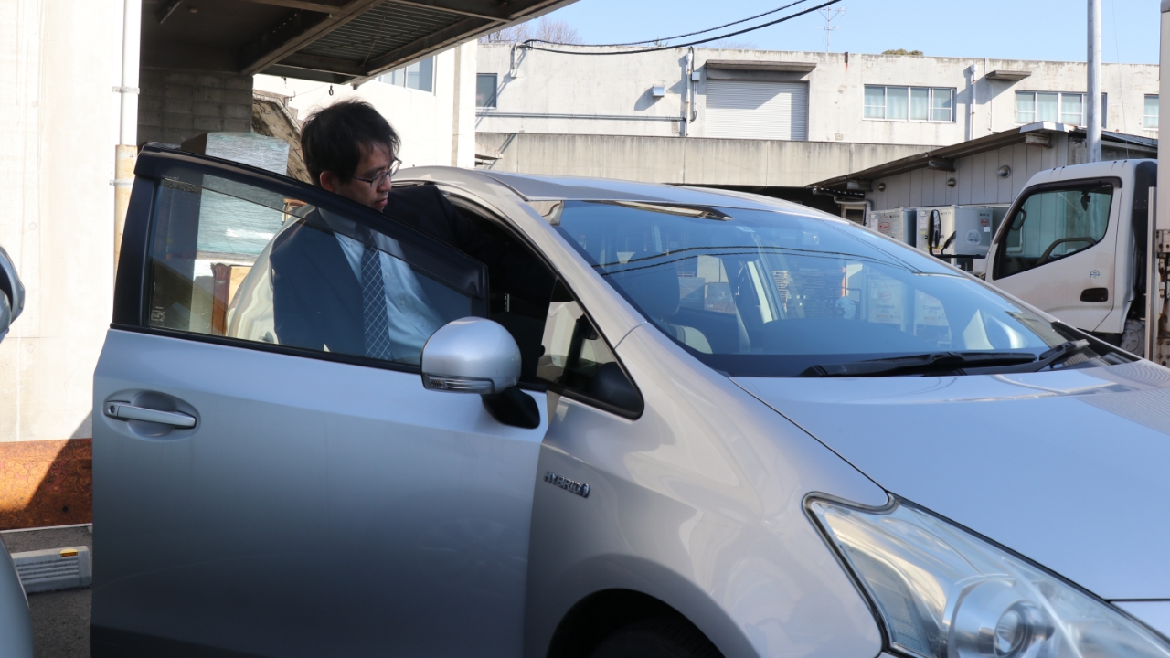 びしっとスーツを着こなし車に乗り込む松本さん。